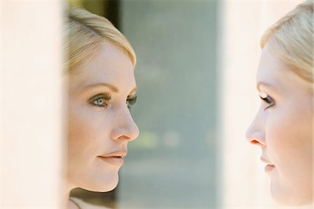 Woman looking at her reflection Photographie de stock - Premium Libres de Droits, Code: 6116-09013662