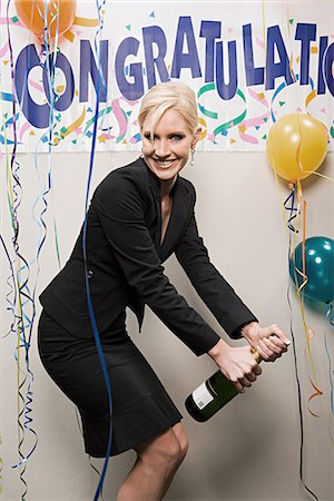 Businesswoman opening bottle of champagne Stock Photo - Premium Royalty-Free, Code: 6116-09013684
