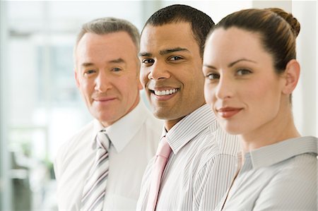 Three office workers in a row Stock Photo - Premium Royalty-Free, Code: 6116-09013623