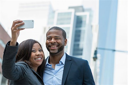 smile couple taking picture phone - Summer. A Couple Taking A Selfy, A Woman Holding Out A Smart Phone And Taking Their Picture. Stock Photo - Premium Royalty-Free, Code: 6118-07121854