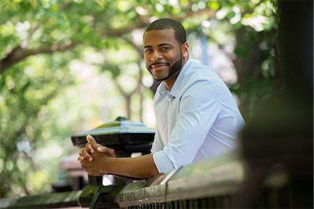 simsearch:6118-07121852,k - Summer. A Man In A White Shirt Leaning On A Railing. Stock Photo - Premium Royalty-Free, Code: 6118-07121882