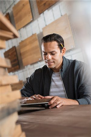 simsearch:6118-09148255,k - A Young Man In A Workshop Which Uses Recycled And Reclaimed Lumber To Create Furniture And Objects. Foto de stock - Sin royalties Premium, Código: 6118-07121800