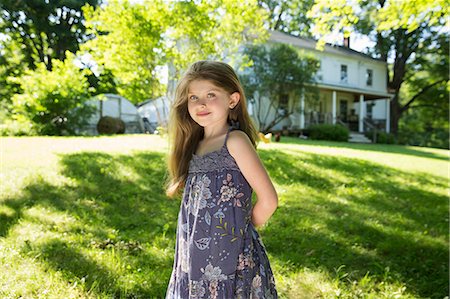 simsearch:6118-07121815,k - Outdoors In Summer. On The Farm. A Girl In The Garden With Her Hands Behind Her Back. Foto de stock - Sin royalties Premium, Código: 6118-07121813