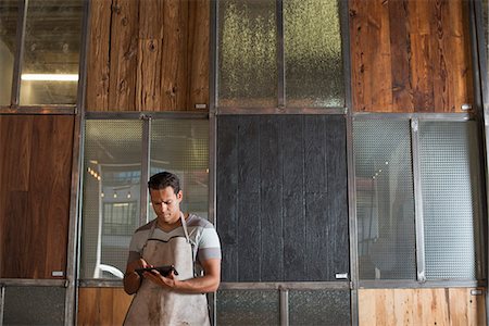 simsearch:6118-07121810,k - A Young Man In A Workshop. Using A Digital Tablet To Keep Records And Photograph Objects. Foto de stock - Sin royalties Premium, Código: 6118-07121810