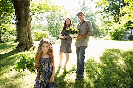 farmer family mature - On The Farm. Two Adults Carrying Cartons Of Fresh Vegetables And Plants. A Girl Carrying Bunches Of Fresh Herbs. Stock Photo - Premium Royalty-Free, Code: 6118-07121816