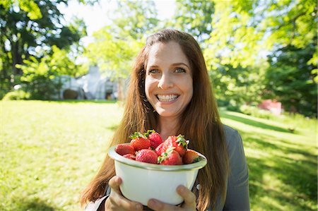 summer dessert - On The Farm. A Woman Carrying A Bowl Of Organic Fresh Picked Strawberries. Foto de stock - Sin royalties Premium, Código: 6118-07121819