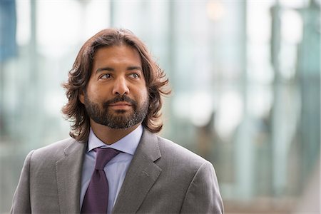 Business People Out And About In The City. A Latino Man In A Suit Jacket And Purple Tie. Stock Photo - Premium Royalty-Free, Code: 6118-07121901