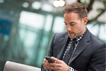 Business People. A Man In A Business Suit. A Man With Short Red Hair And A Beard, Wearing A Suit, On His Phone. Stock Photo - Premium Royalty-Free, Code: 6118-07121911