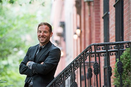 Business People. A Man In A Suit On The Steps Of A Brownstone Building. Arms Folded. Stock Photo - Premium Royalty-Free, Code: 6118-07121929