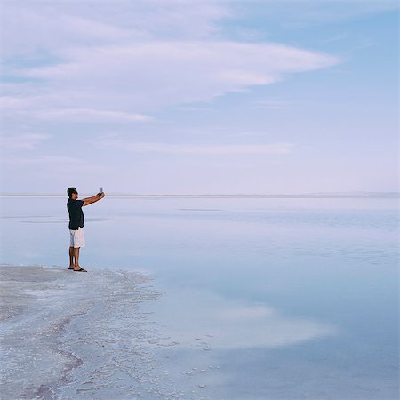 simsearch:6118-07122077,k - A Man Standing At Edge Of The Flooded Bonneville Salt Flats At Dusk, Taking A Photograph With A Tablet Device, Near Wendover. Stockbilder - Premium RF Lizenzfrei, Bildnummer: 6118-07122062