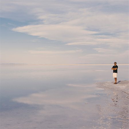 simsearch:6118-08827578,k - A Man Standing At Edge Of The Flooded Bonneville Salt Flats At Dusk. Arms Folded. Stockbilder - Premium RF Lizenzfrei, Bildnummer: 6118-07122065