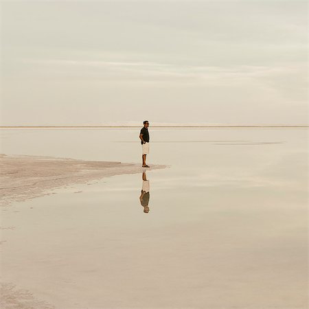simsearch:6118-07122048,k - A Man Standing At The Edge Of The Flooded Bonneville Salt Flats At Dusk. Stock Photo - Premium Royalty-Free, Code: 6118-07122066