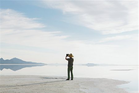 simsearch:878-07442477,k - A Man Standing At Edge Of The Flooded Bonneville Salt Flats At Dusk, Taking A Photograph With A Tablet Device. Foto de stock - Sin royalties Premium, Código: 6118-07122077