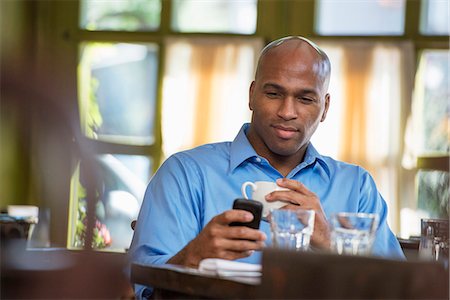 Business People. A Man Sitting Checking His Phone. Photographie de stock - Premium Libres de Droits, Code: 6118-07122004