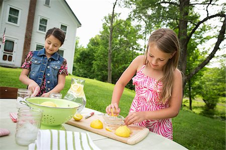 simsearch:6118-07121827,k - A Summer Family Gathering At A Farm. Two Girls Working Together, Making Homemade Lemonade. Foto de stock - Sin royalties Premium, Código: 6118-07122153