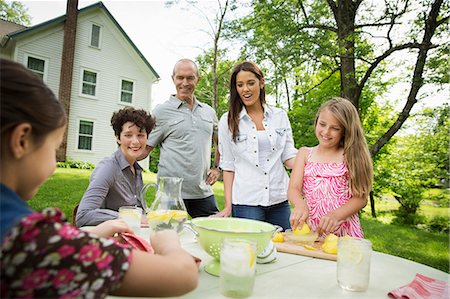 family gathering - A Summer Family Gathering At A Farm. A Girl Slicing And Juicing Lemons To Make Lemonade. Stock Photo - Premium Royalty-Free, Code: 6118-07122156