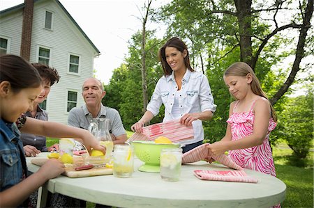 simsearch:6118-07121827,k - A Summer Family Gathering At A Farm. A Family Group, Parents And Children. Making Fresh Lemonade. Foto de stock - Sin royalties Premium, Código: 6118-07122163