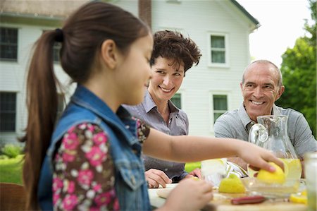 simsearch:6118-07203440,k - A Summer Family Gathering At A Farm. A Family Group, Parents And Children. Making Fresh Lemonade. Stock Photo - Premium Royalty-Free, Code: 6118-07122162