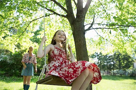 Summer. A Girl In A Sundress On A Swing Hanging From A Tree Branch. A Woman Behind Her. Photographie de stock - Premium Libres de Droits, Code: 6118-07122209
