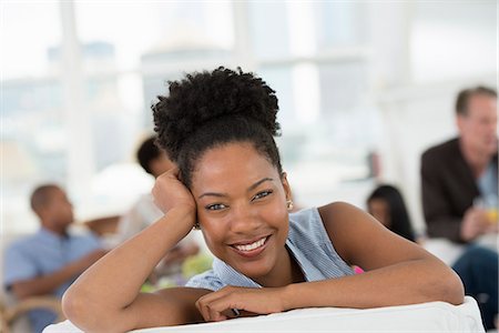 simsearch:6118-07122385,k - Group Of People. A Young Woman Smiling Broadly. Photographie de stock - Premium Libres de Droits, Code: 6118-07122350