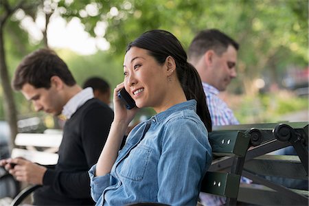 simsearch:6118-07122318,k - Summer In The City. One Woman And Three Men Sitting In The Park, Each On Their Own Phone Or Using A Tablet. Stock Photo - Premium Royalty-Free, Code: 6118-07122314