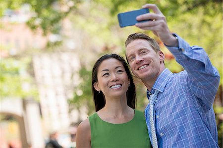 photographing with mobile usa - A Couple, A Man And Woman Taking A Selfy With A Smart Phone. Stock Photo - Premium Royalty-Free, Code: 6118-07122457