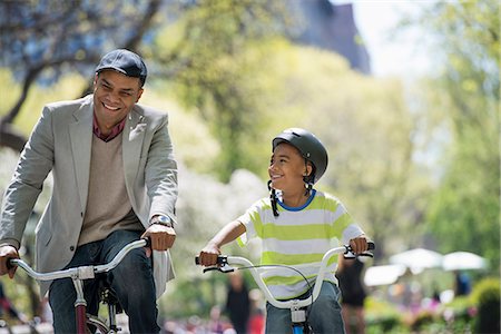A Family In The Park On A Sunny Day. Father And Son Bicycling Foto de stock - Sin royalties Premium, Código: 6118-07122490