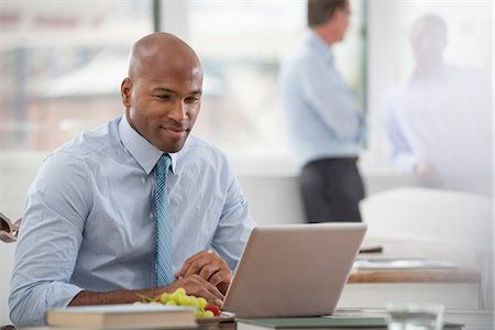 Office Life. A Businessman In A Shirt And Tie Sitting At A Desk, Using A Laptop Computer. Foto de stock - Sin royalties Premium, Código: 6118-07122423