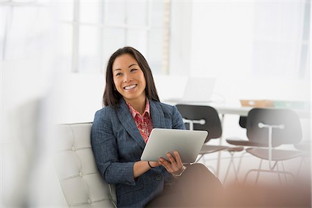 female sitting office chair - Business. A Woman Sitting Down Using A Digital Tablet. Stock Photo - Premium Royalty-Free, Code: 6118-07122547
