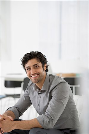 simsearch:6118-07122570,k - Business. A Man Seated With His Hands Clasped In A Relaxed Pose. Smiling And Leaning Forwards. Foto de stock - Sin royalties Premium, Código: 6118-07122557