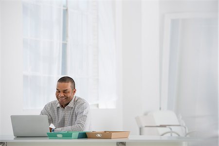 Business. A Man Sitting At A Desk Using A Laptop. Foto de stock - Sin royalties Premium, Código: 6118-07122585