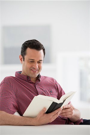 shirt collar - A Bright White Room Interior. A Man Sitting Reading A Book. Stock Photo - Premium Royalty-Free, Code: 6118-07122651