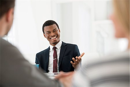 simsearch:6118-07122641,k - Office Interior. Three People Sitting Around A Table At A Business Meeting. Stock Photo - Premium Royalty-Free, Code: 6118-07122674