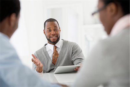 simsearch:6118-07122661,k - Office Interior. Three People Sitting Around A Table At A Business Meeting. Foto de stock - Sin royalties Premium, Código: 6118-07122678