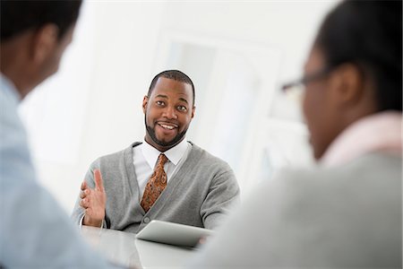 simsearch:6118-07122641,k - Office Interior. Three People Sitting Around A Table At A Business Meeting. Stock Photo - Premium Royalty-Free, Code: 6118-07122679