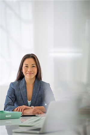 Business. A Woman Sitting At A Desk. Digital Tablet And Laptop, And Green Files. Stockbilder - Premium RF Lizenzfrei, Bildnummer: 6118-07122606