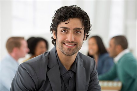 efficient - Business Meeting. A Group Sitting Down Around A Table. A Man Smiling Confidently. Stock Photo - Premium Royalty-Free, Code: 6118-07122619