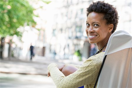 simsearch:6118-07122772,k - City Life. A Woman Sitting In A Camping Chair In A City Park Looking Over Her Shoulder. Stock Photo - Premium Royalty-Free, Code: 6118-07122765