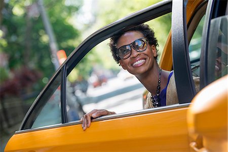 A Woman Getting Out Of The Rear Passenger Seat Of A Yellow Cab. Stock Photo - Premium Royalty-Free, Code: 6118-07122773
