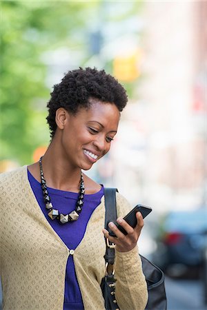 City. A Woman In A Purple Dress Checking Her Smart Phone. Foto de stock - Sin royalties Premium, Código: 6118-07122785