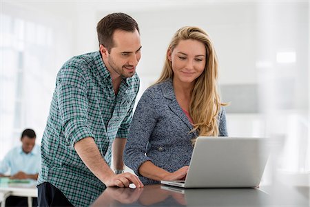 sprechen - Office Interior. A Couple At A Table Looking At A Computer Screen. Stockbilder - Premium RF Lizenzfrei, Bildnummer: 6118-07122722