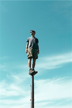 sentido único - Man standing and balancing on metal post, looking towards expansive sky, Surprise Mountain, Alpine Lakes Wilderness, Mt. Baker-Snoqualmie national forest. Foto de stock - Sin royalties Premium, Código: 6118-07202952