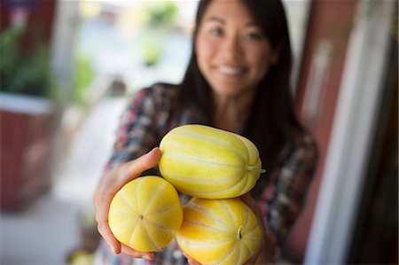 fruits bio - A farm growing and selling organic vegetables and fruit. A woman holding freshly harvested striped squashes. Photographie de stock - Premium Libres de Droits, Code: 6118-07202974