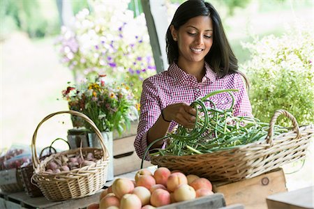 simsearch:6118-07203001,k - A farm stand with fresh organic vegetables and fruit. A woman holding bunches of carrots. Foto de stock - Sin royalties Premium, Código: 6118-07202997