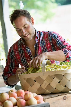 simsearch:6118-07203002,k - A farm stand with fresh organic vegetables and fruit. A man sorting beans in a basket. Foto de stock - Royalty Free Premium, Número: 6118-07202999