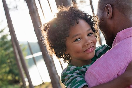 simsearch:6118-07203063,k - Trees on the shores of a lake. A man carrying a child in his arms. Stock Photo - Premium Royalty-Free, Code: 6118-07203071