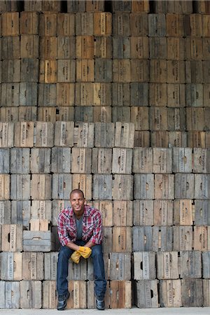 simsearch:6118-07440282,k - A farmyard. A stack of traditional wooden crates for packing fruit and vegetables. A man sitting on a packing case. Photographie de stock - Premium Libres de Droits, Code: 6118-07203027