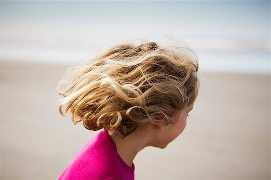 A six year old child on the beach, at Long Beach Peninsula with windblown hair. Stock Photo - Premium Royalty-Free, Image code: 6118-07203178