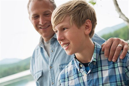 simsearch:6118-07203856,k - A family outdoors under the trees on a lake shore. Father and son. Foto de stock - Royalty Free Premium, Número: 6118-07203115