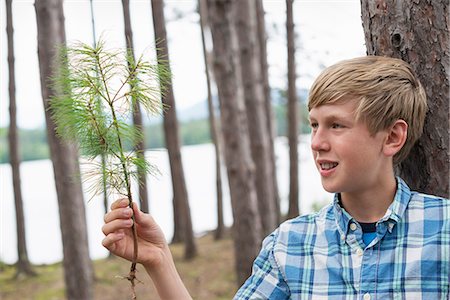 simsearch:6118-07732023,k - A boy standing among trees on the shore of a lake. Photographie de stock - Premium Libres de Droits, Code: 6118-07203125